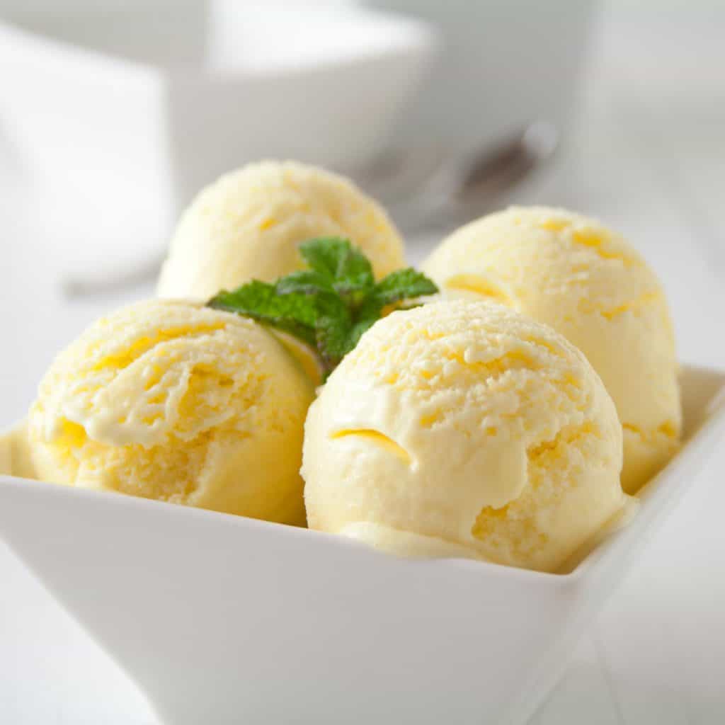 Mango gelato in a white bowl on a table