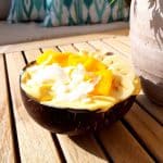 Tropical nice cream in a coconut bowl on a wooden table